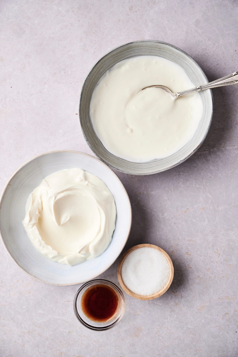 A countertop with a bowl of creme fraiche, heavy cream, sugar, and vanilla.