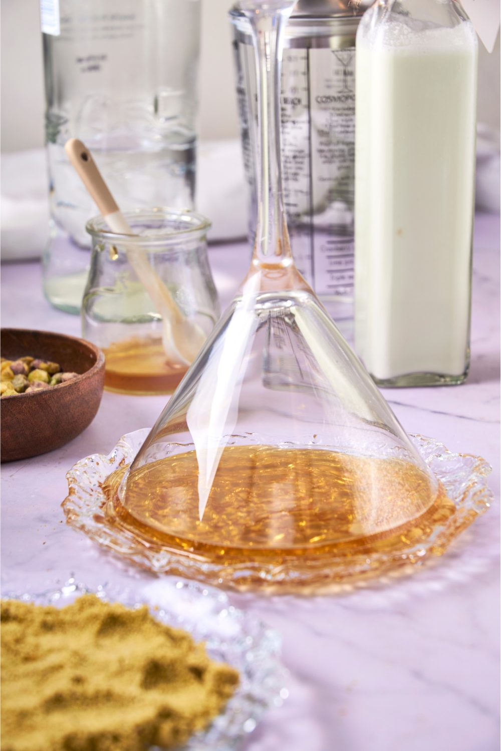 A martini glass being dipped into the honey.