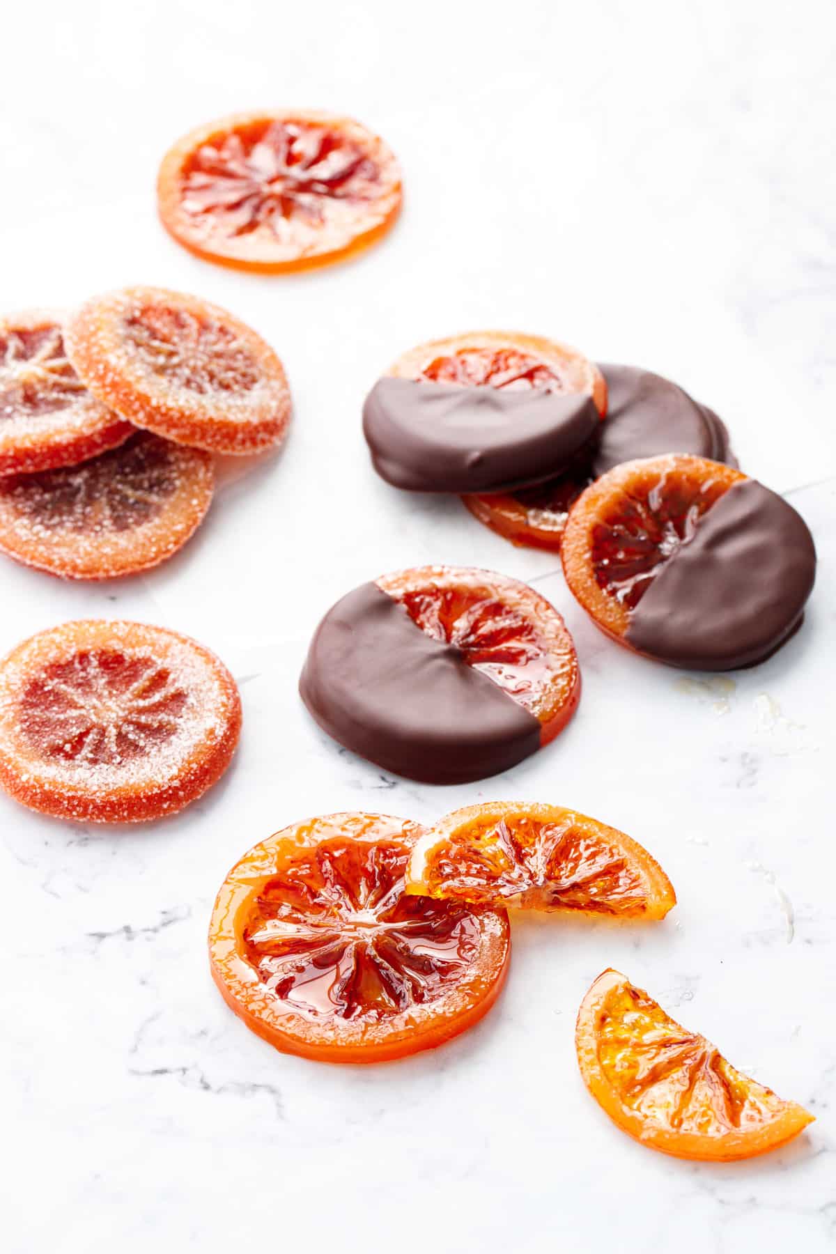 Homemade Candied Blood Orange Slices finished in 3 ways: dried and left clear and shiny, dipped in dark chocolate, and coated in granulated sugar.