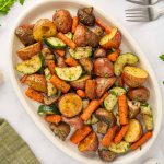 A large platter is filled with oven roasted vegetables.