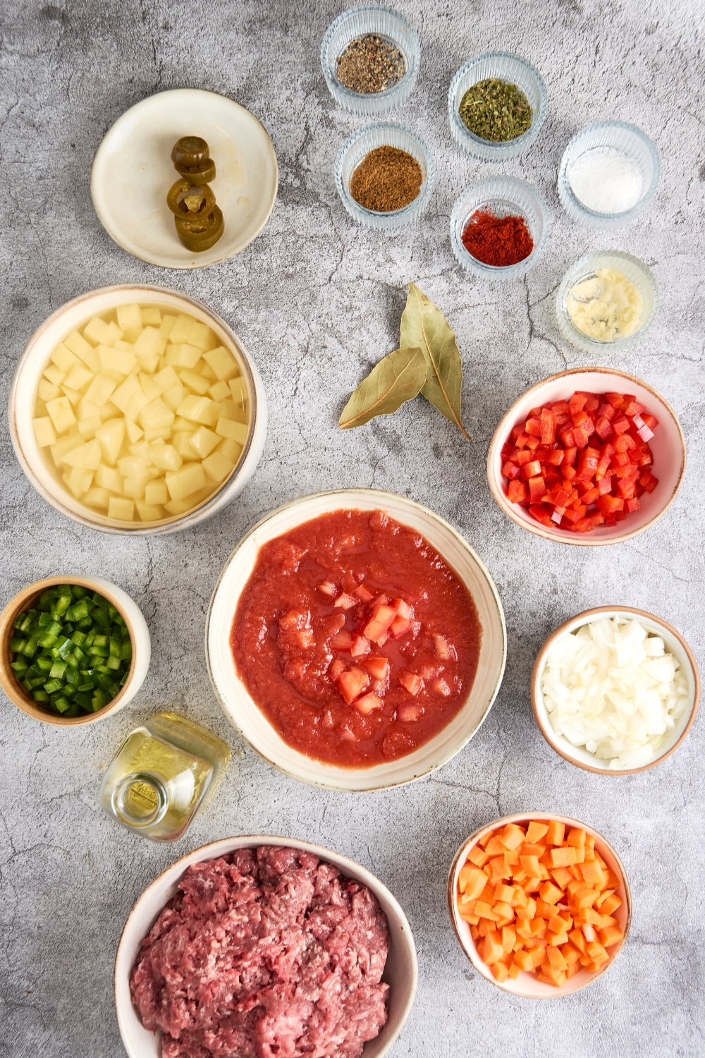 A countertop with multiple bowls with the ingredients to make mexican picadillo.