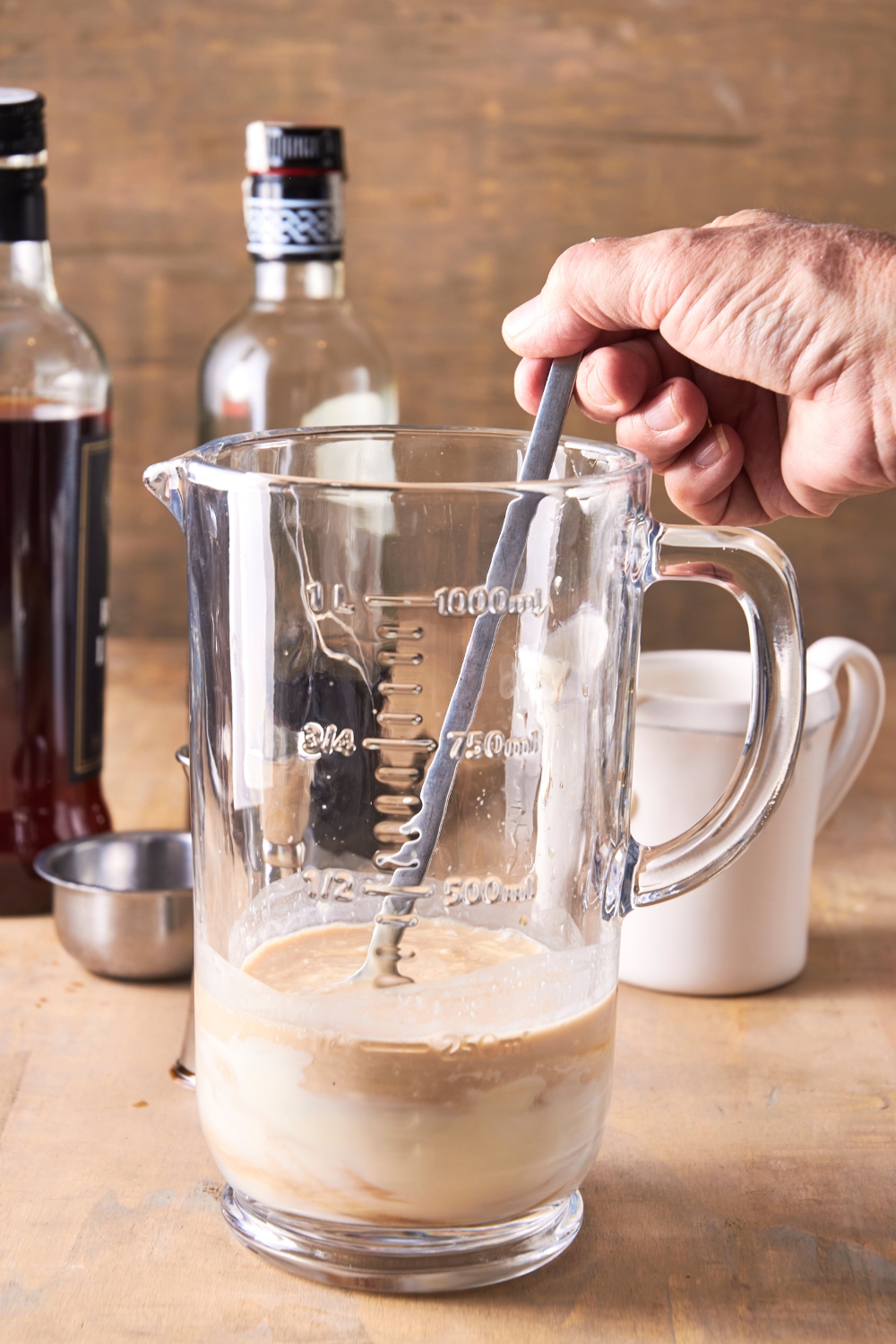A pitcher with bourbon cream being mixed.