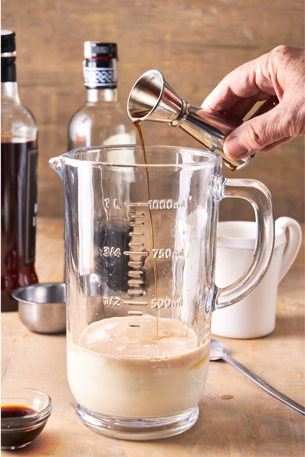 A blender with the vanilla extract bering poured in.