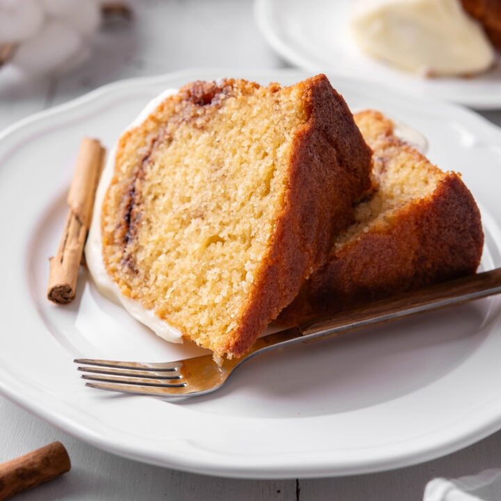 Two slices of cinnamon swirl bundt cake on a white plate.