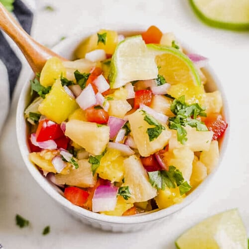 mango pineapple salsa in a serving bowl with fresh cilantro